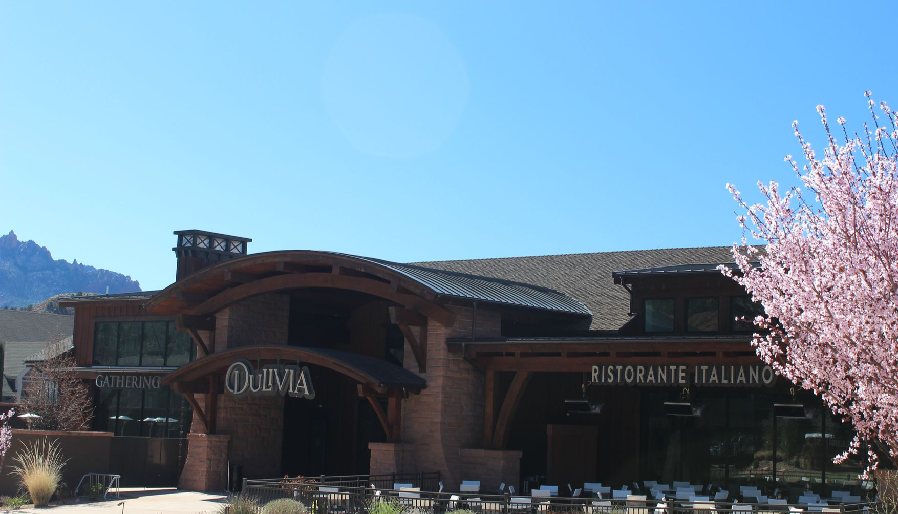 A large brick building with a mountain in the background.