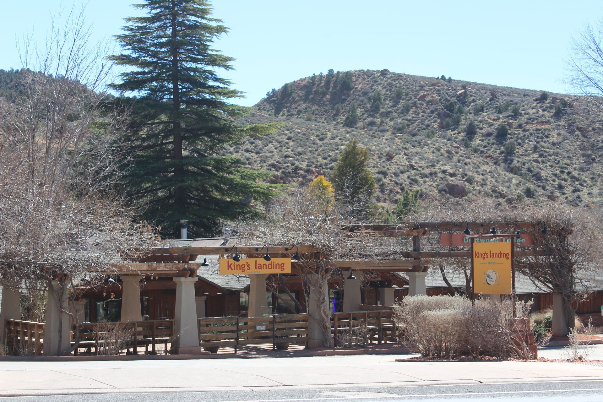 The entrance to king 's landing restaurant with a mountain in the background