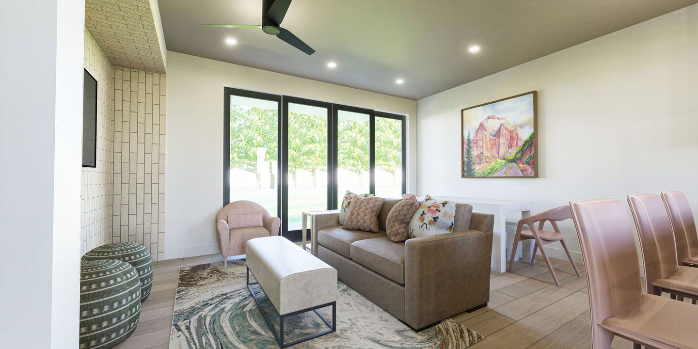 A living room with a couch , chairs , table and a ceiling fan.