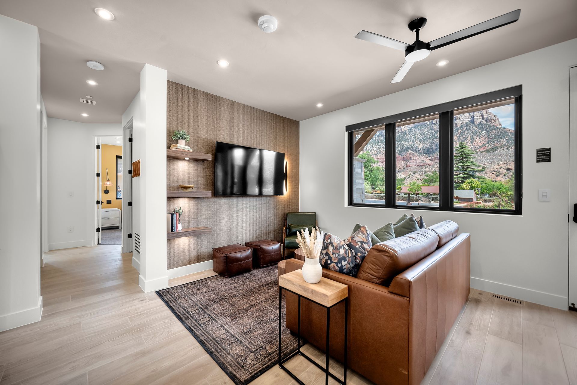 A living room with a couch and a flat screen tv on the wall.