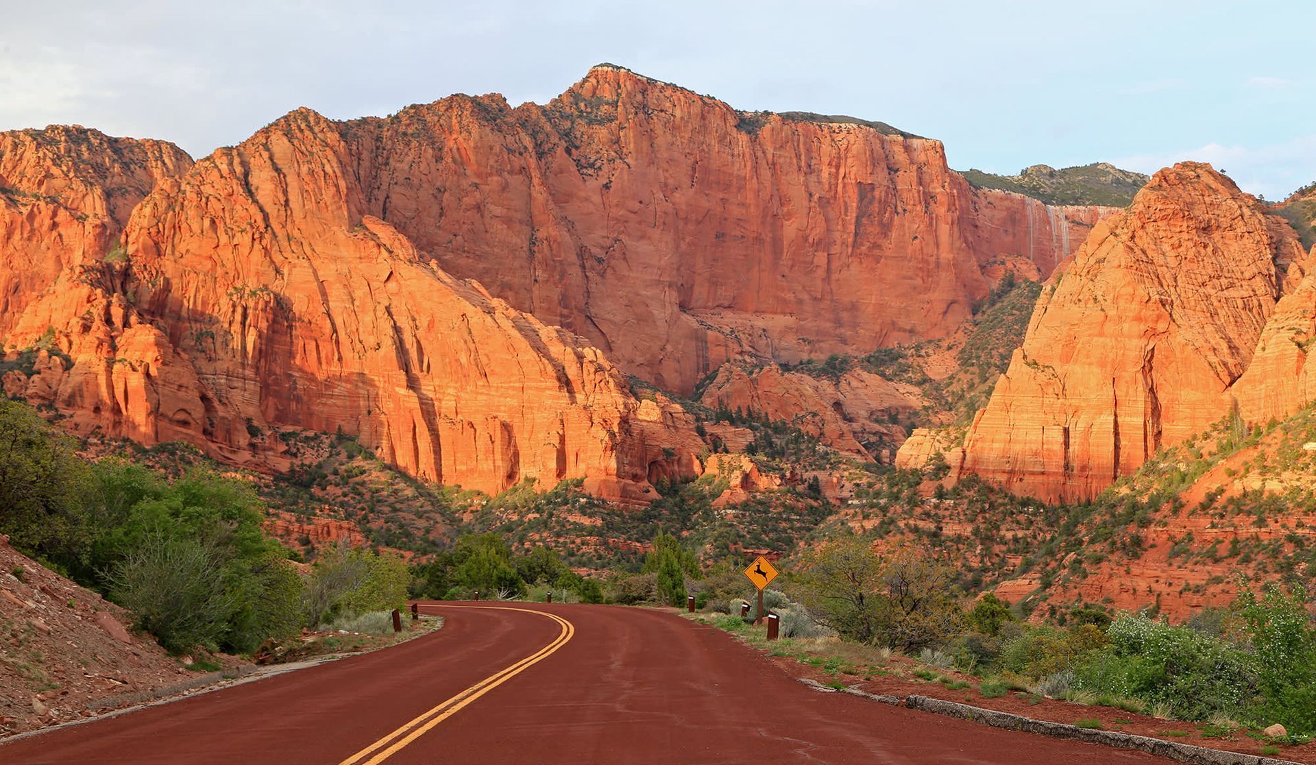 A road going through a canyon with mountains in the background.