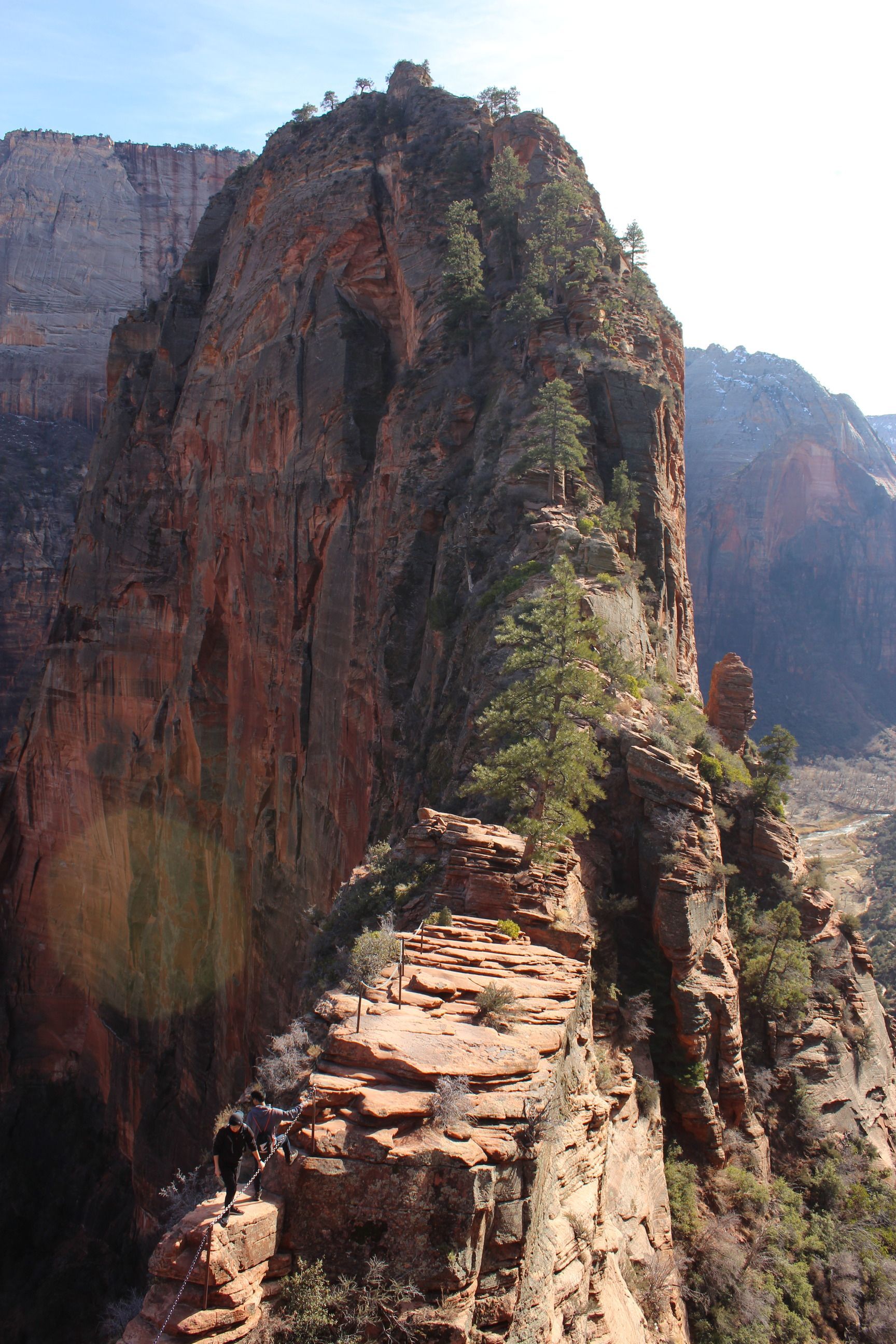 A person with a backpack is standing on top of a mountain.