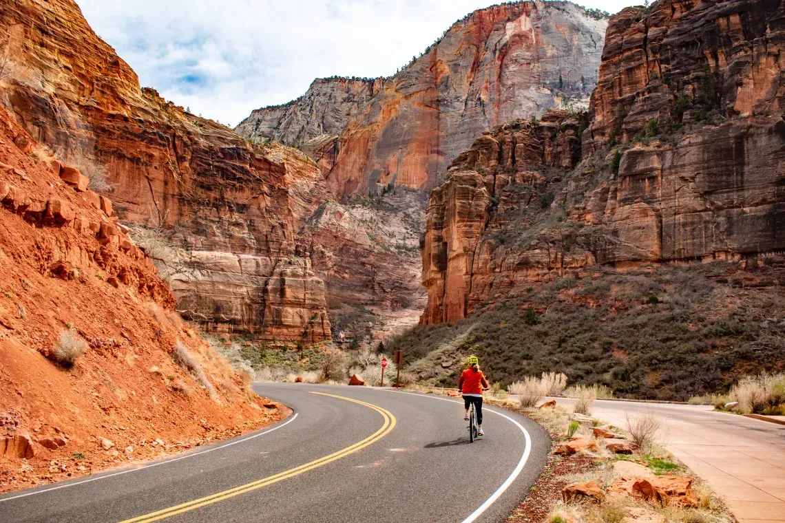 A woman and a child are riding bikes on a trail in the mountains.
