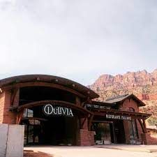 A large brick building with a mountain in the background.
