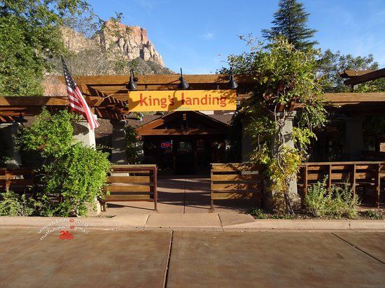 The entrance to king 's landing restaurant with a mountain in the background