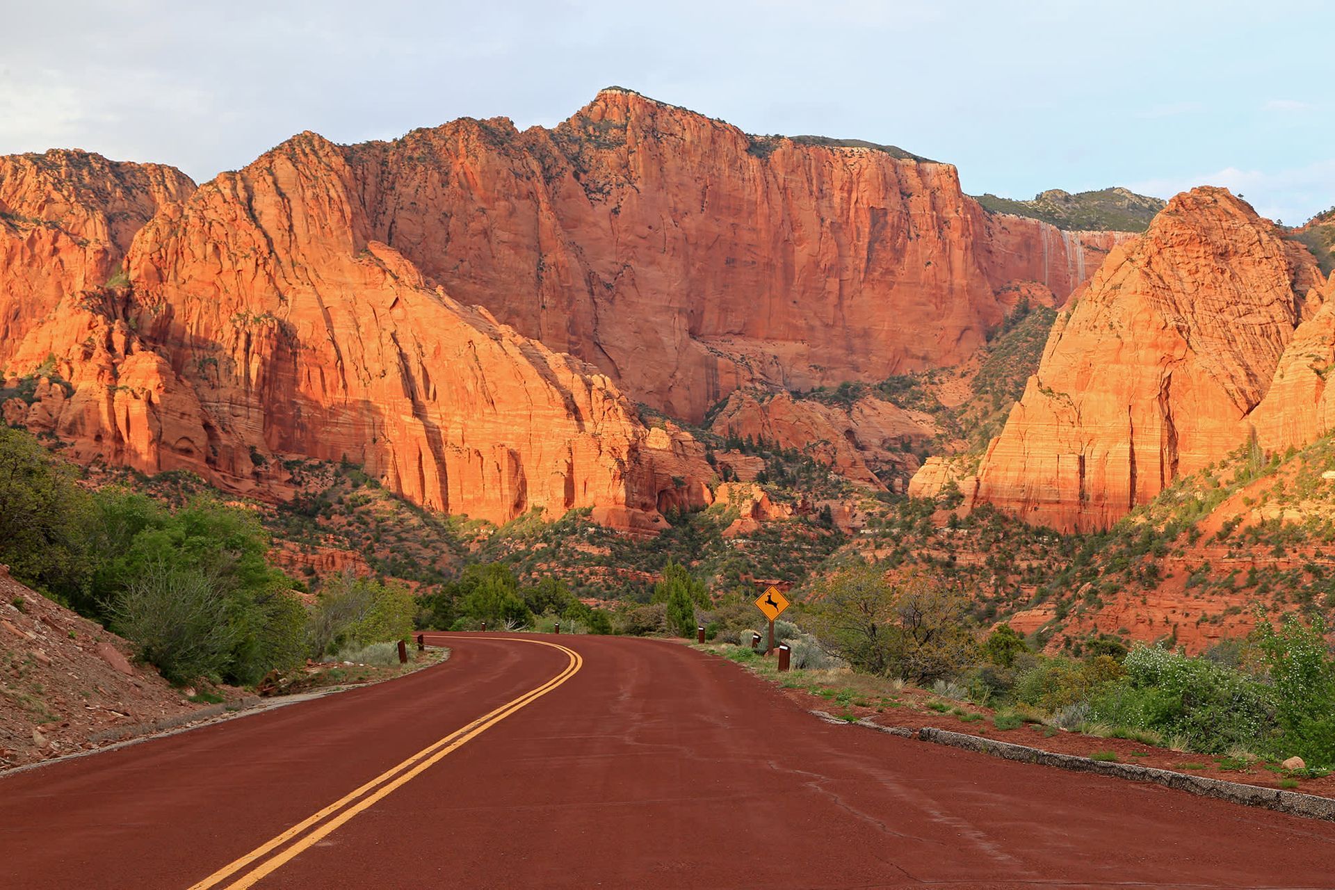 A road going through a canyon with mountains in the background.
