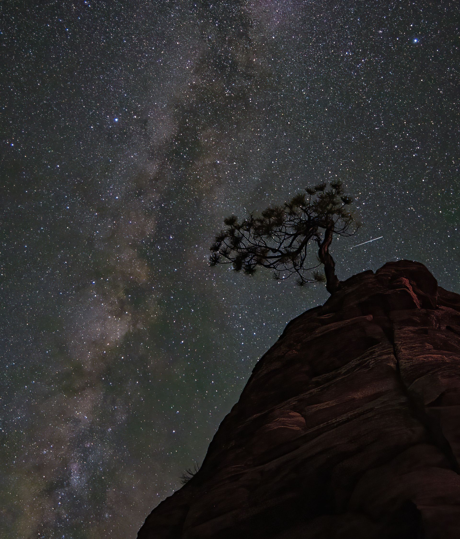A starry night sky with mountains in the foreground
