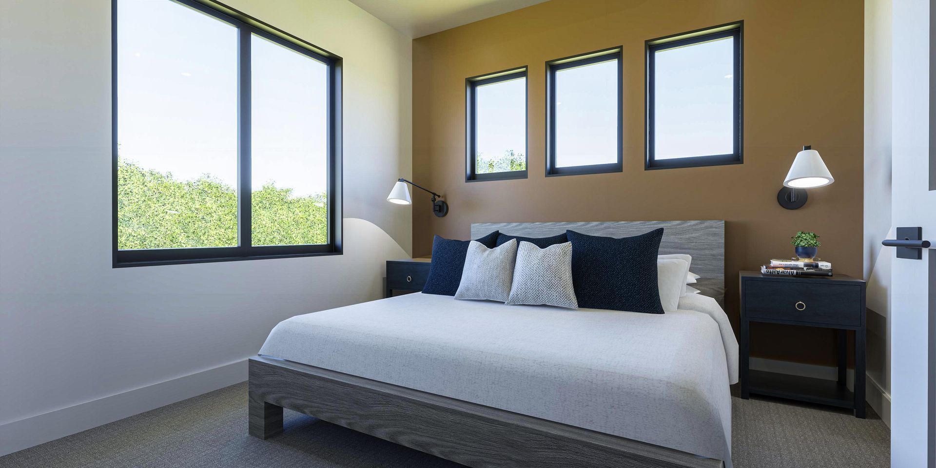 A bedroom with a king size bed and three windows.