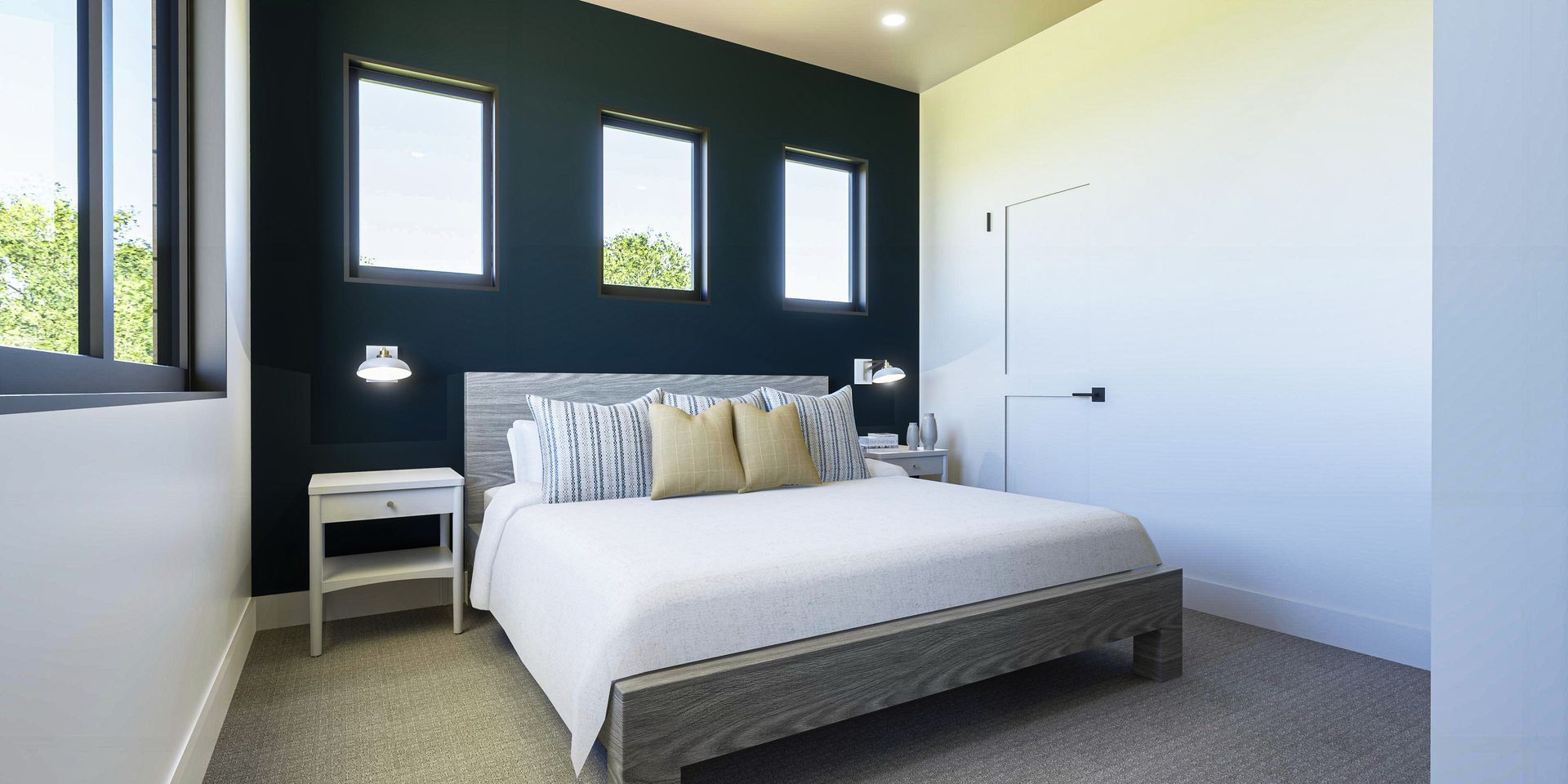 A bedroom with a king size bed , nightstands , and three windows.