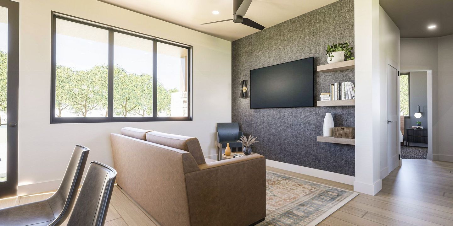 A living room with a couch and a flat screen tv on the wall.