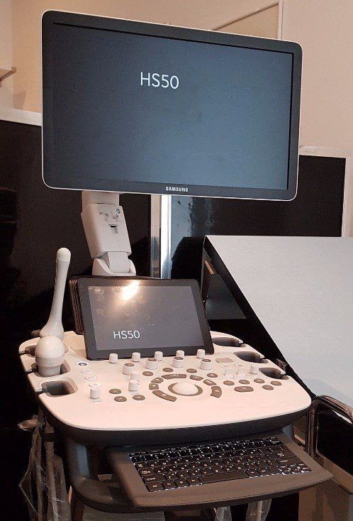 Ecografo con ampio monitor, pannello di controllo e tastiera. Una sonda è appoggiata lateralmente.