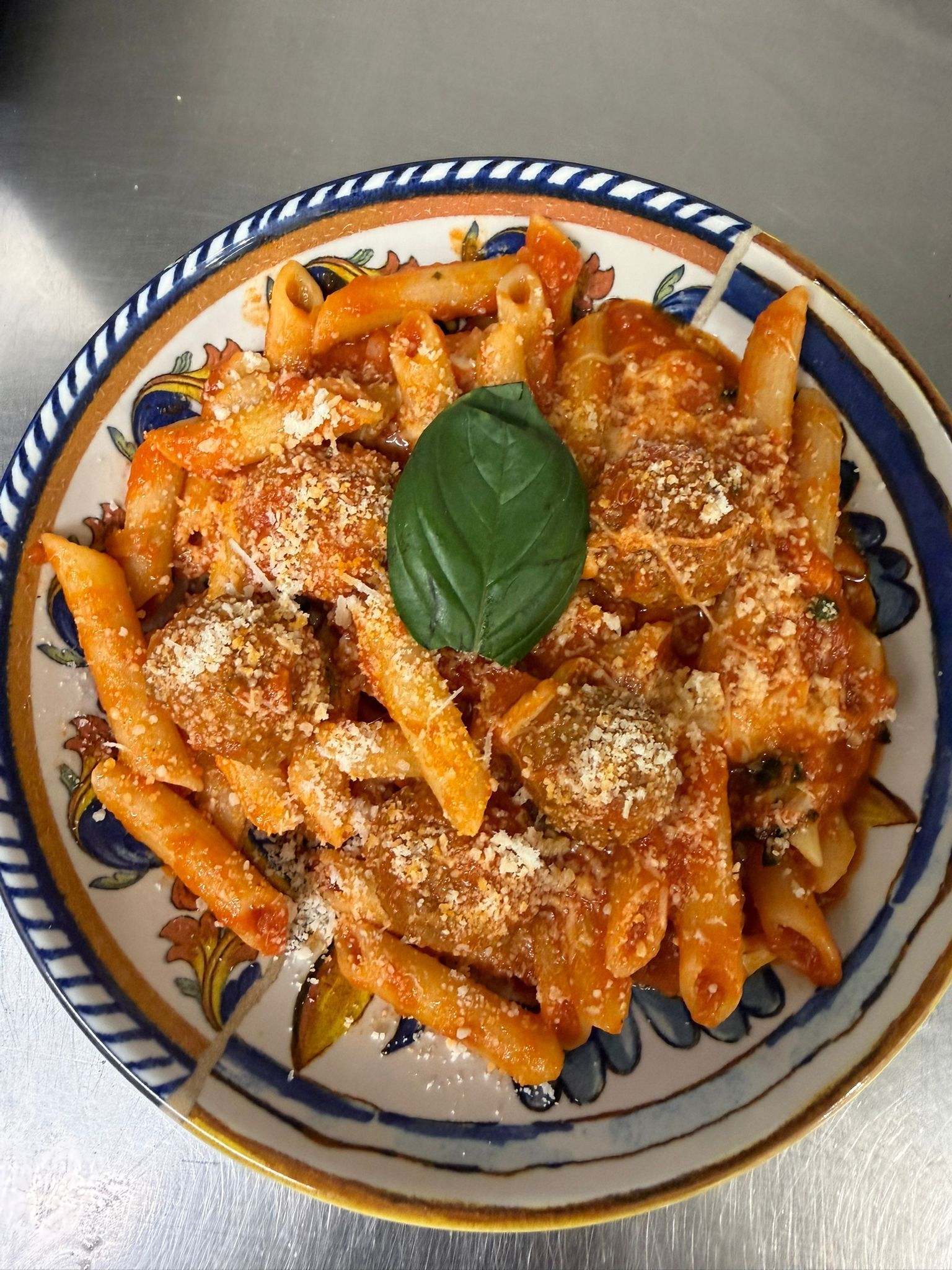 Pizza su un piatto bianco, condita con salsa verde, gialla e rossa in tre sezioni verticali.