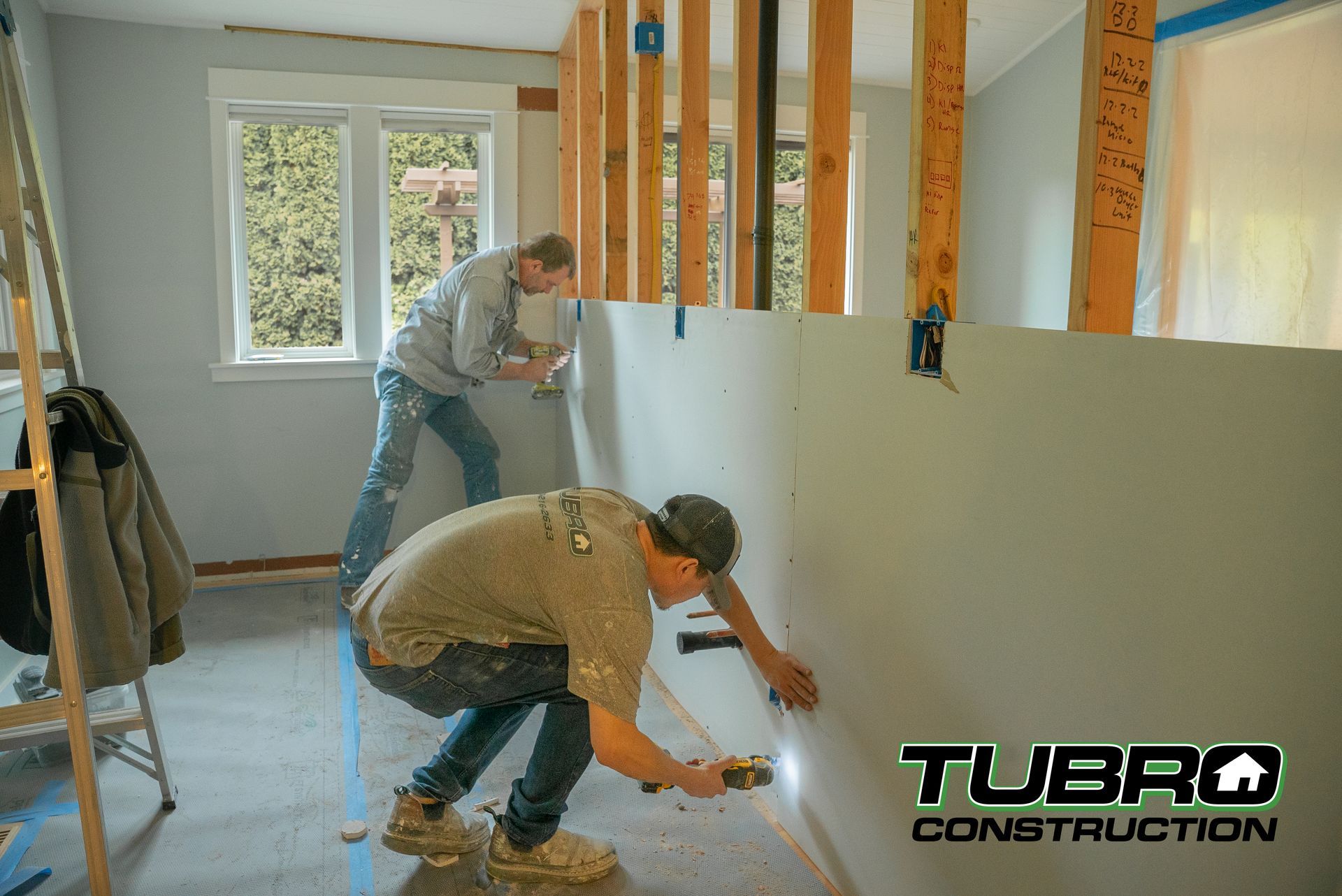 Workers installing new wall during a home renovation