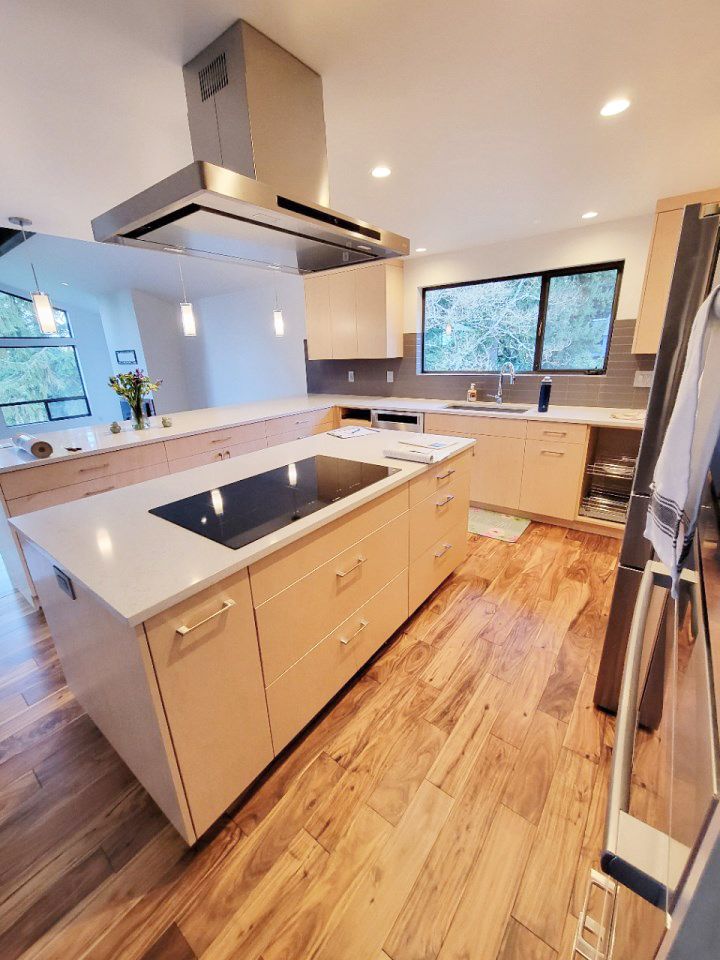 A kitchen with a large island and a stove top oven.