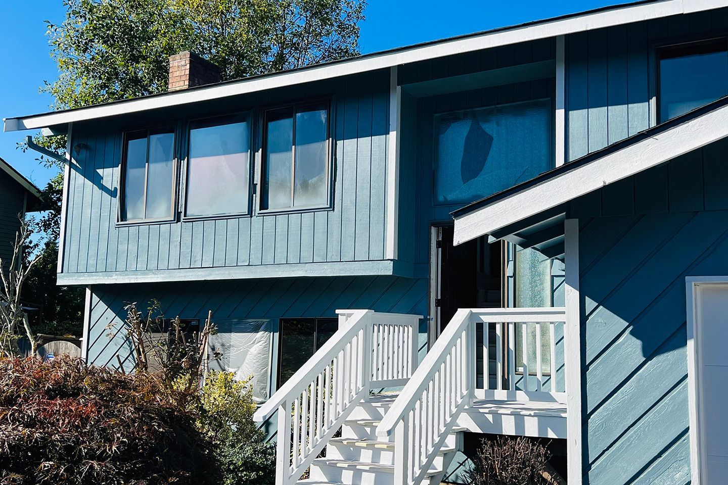 A blue house with white stairs leading up to it