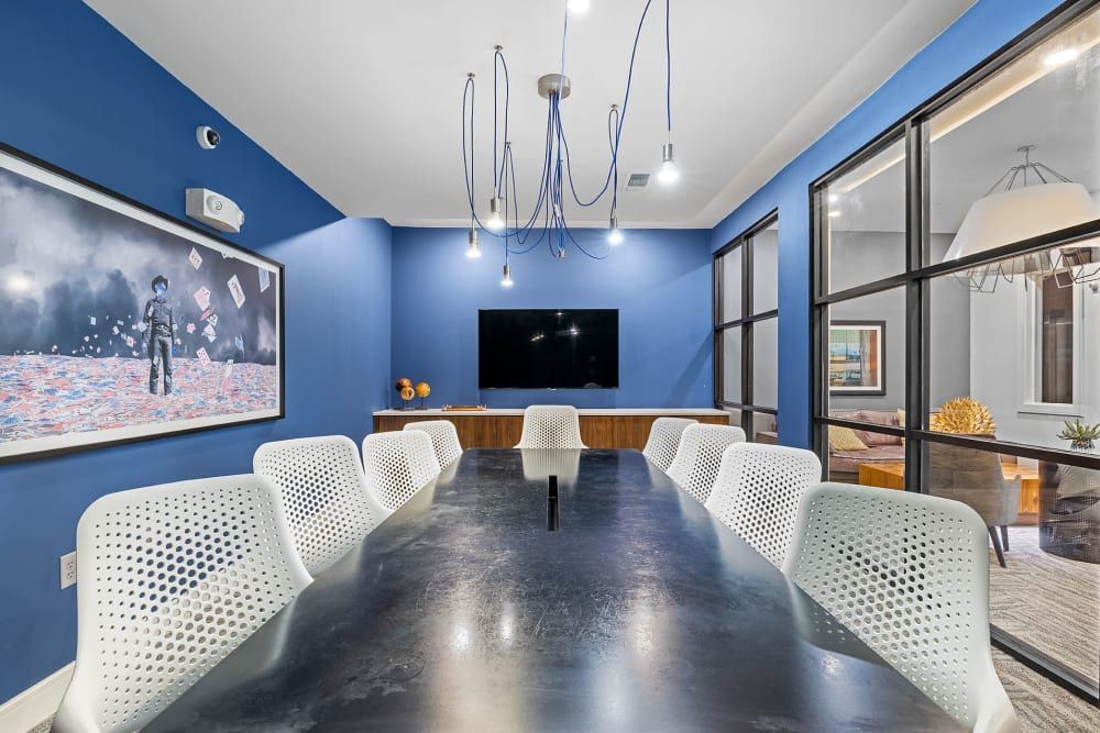 A conference room with a long table and chairs and a flat screen tv at Water's Edge.