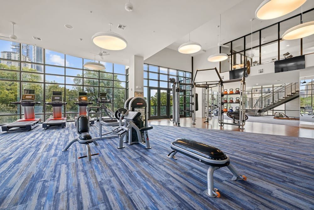 A large gym filled with lots of exercise equipment and a bench at Water's Edge.