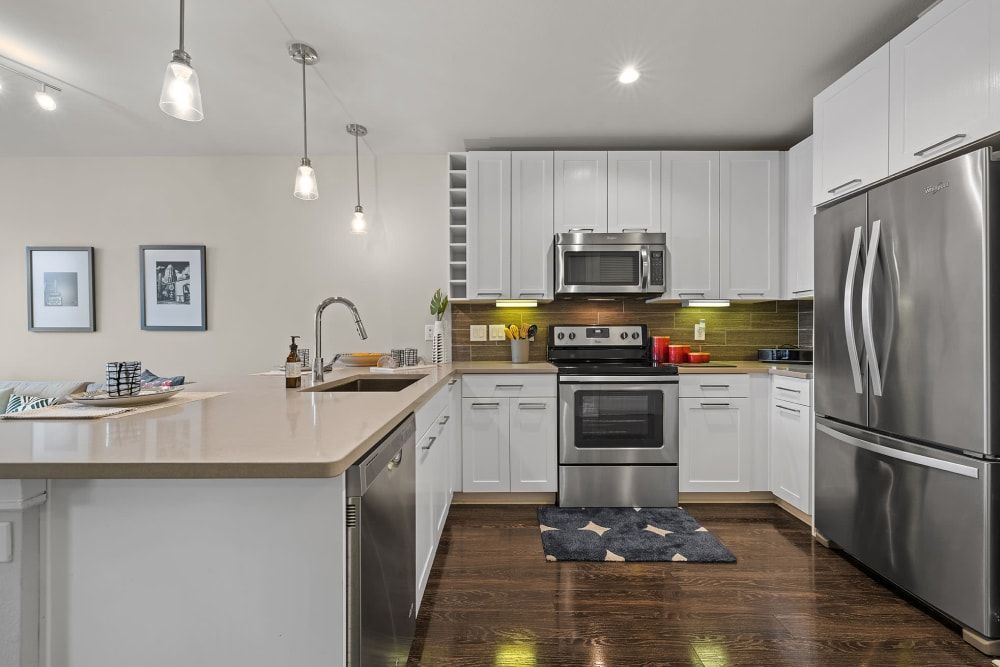 A kitchen with stainless steel appliances and white cabinets  at Water's Edge.