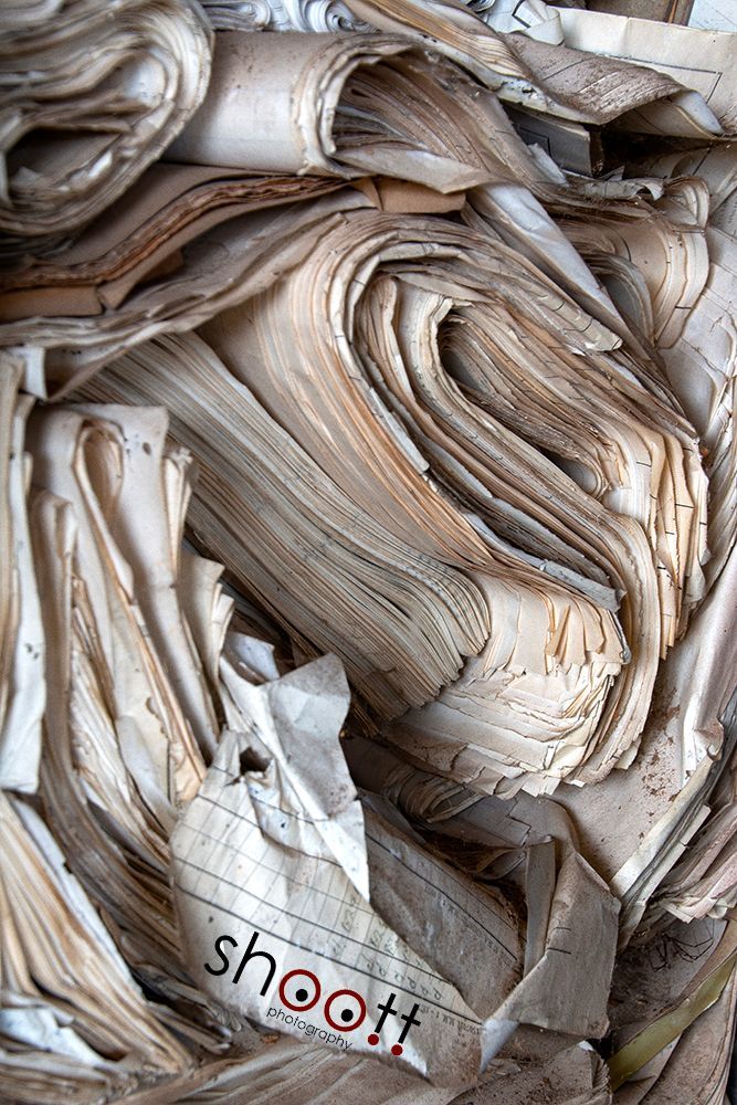 Een close-up van een stapel verweerde, vergeelde en gescheurde papieren.