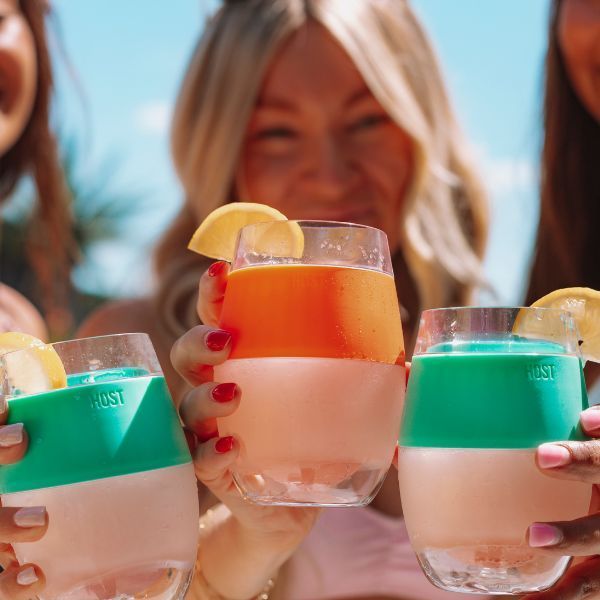 A group of women are holding glasses with lemon slices in them