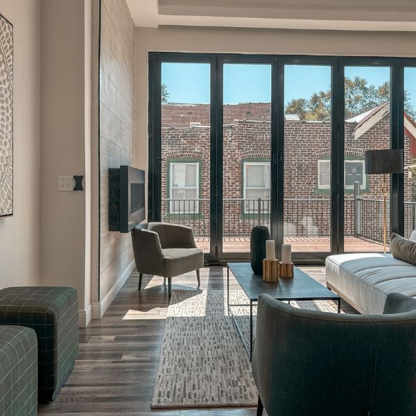 A living room with a couch and chairs and a large window