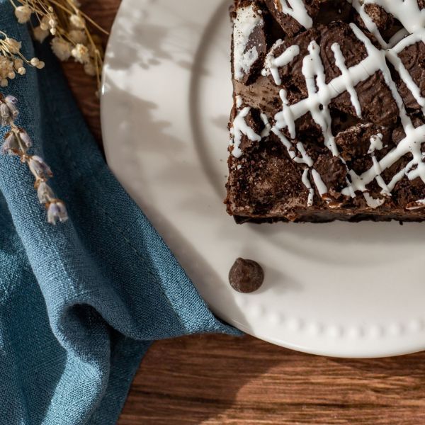 A white plate with a piece of brownie on it