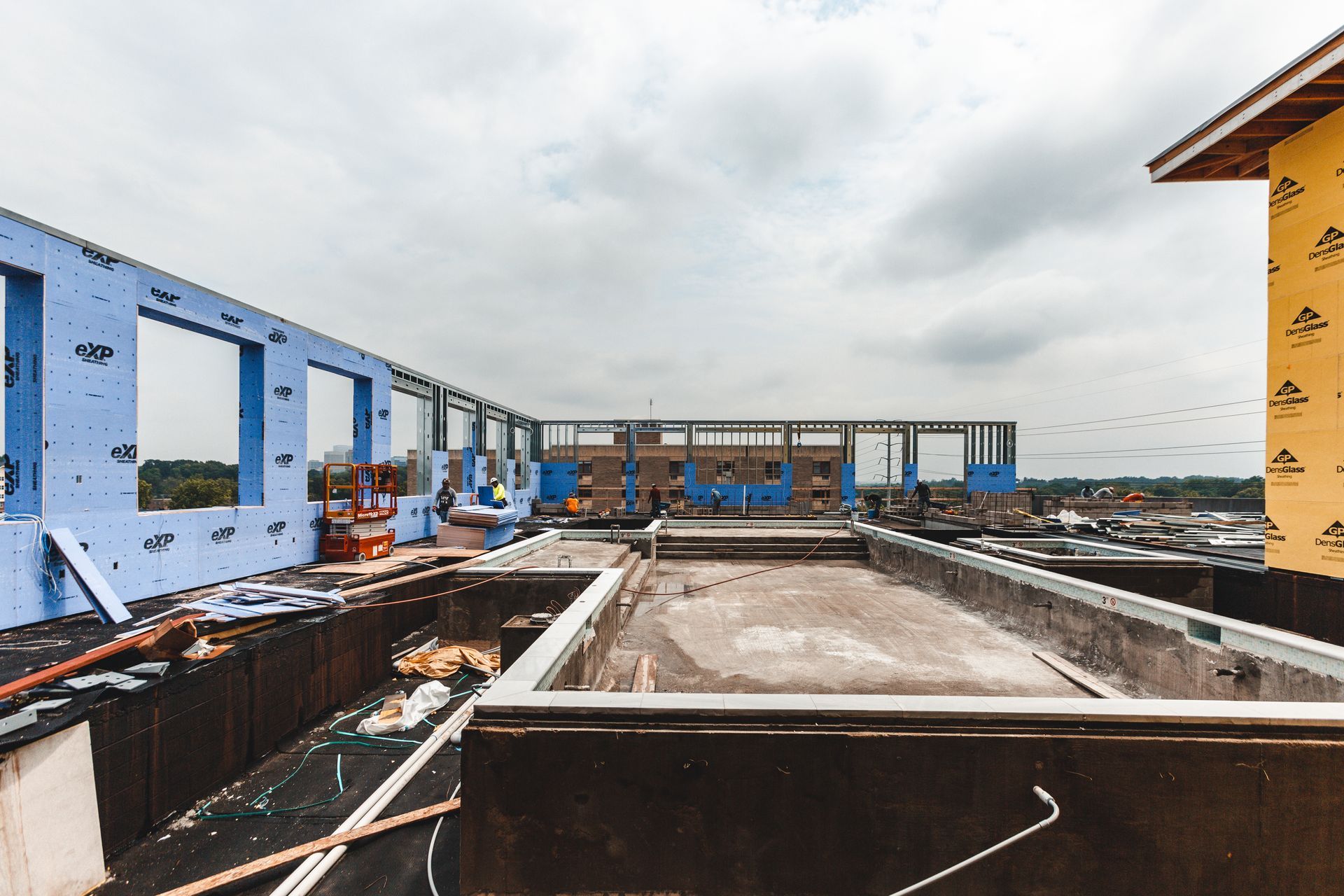 A large pool is being built on the roof of a building under construction.