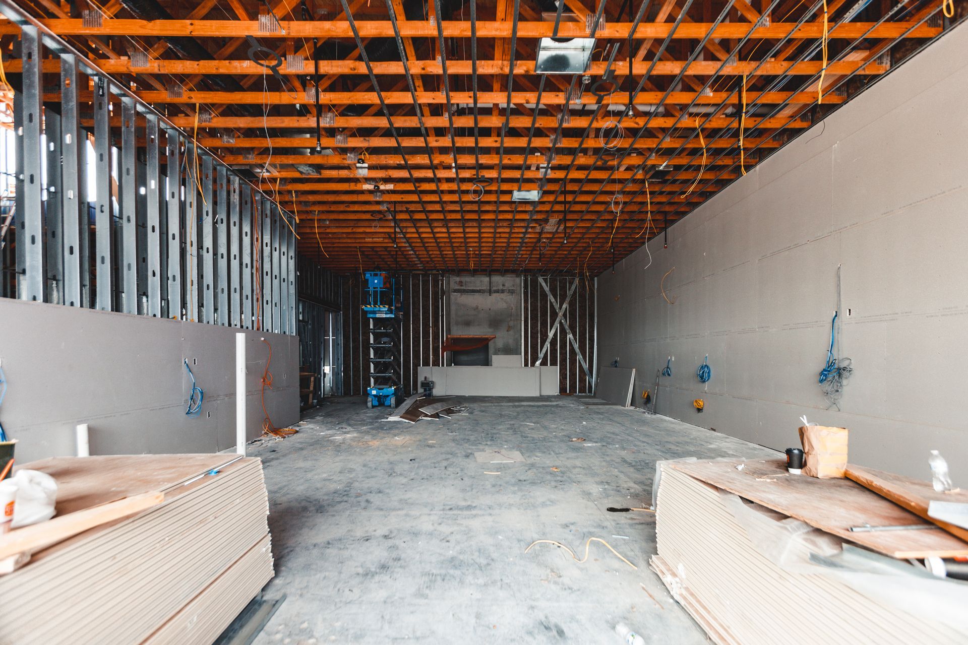 A large empty room under construction with a wooden ceiling.