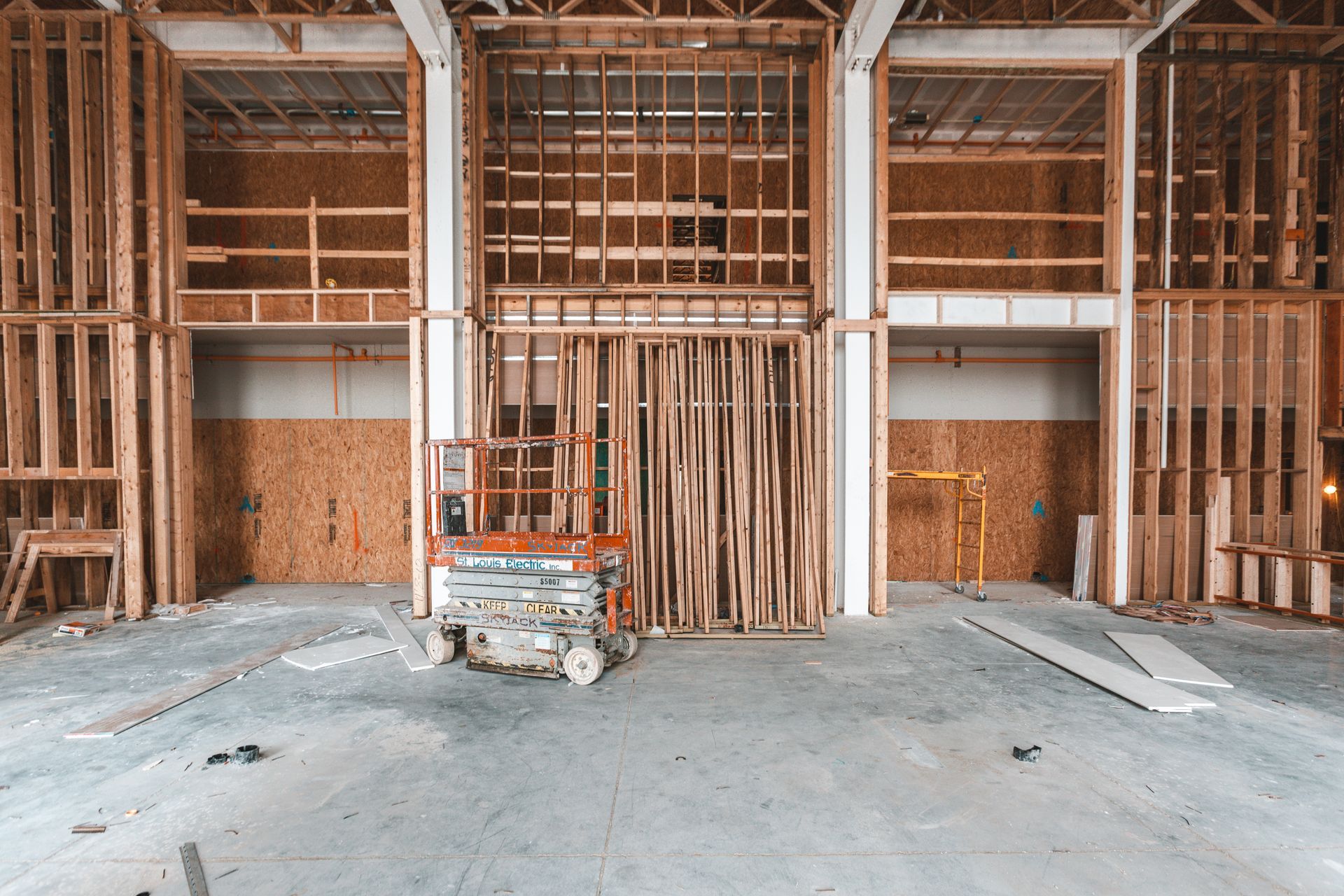 A building under construction with a scissor lift in the middle