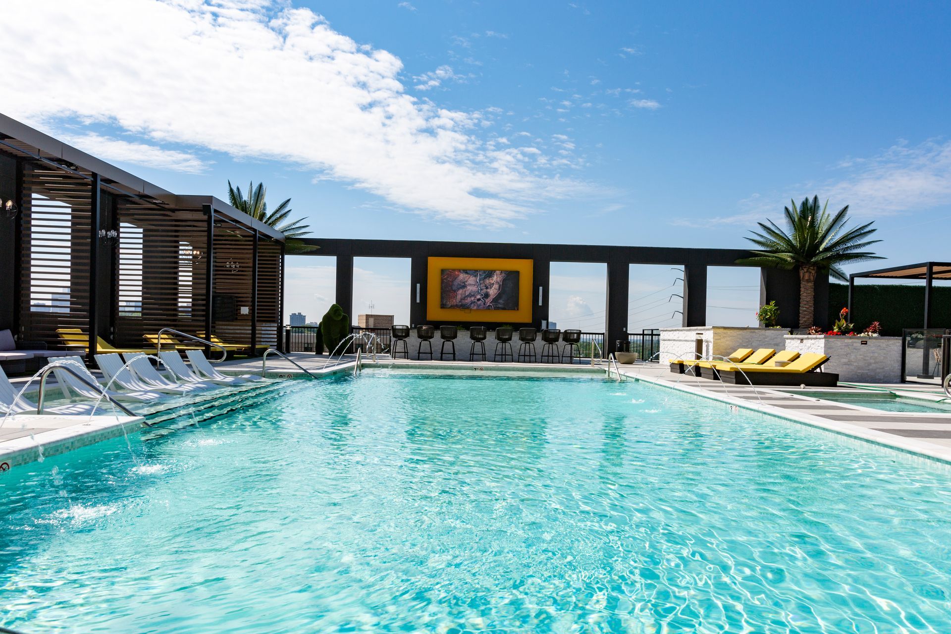 There is a large swimming pool on the roof of a building.