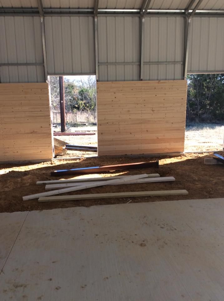 A building under construction with wooden walls and a large window