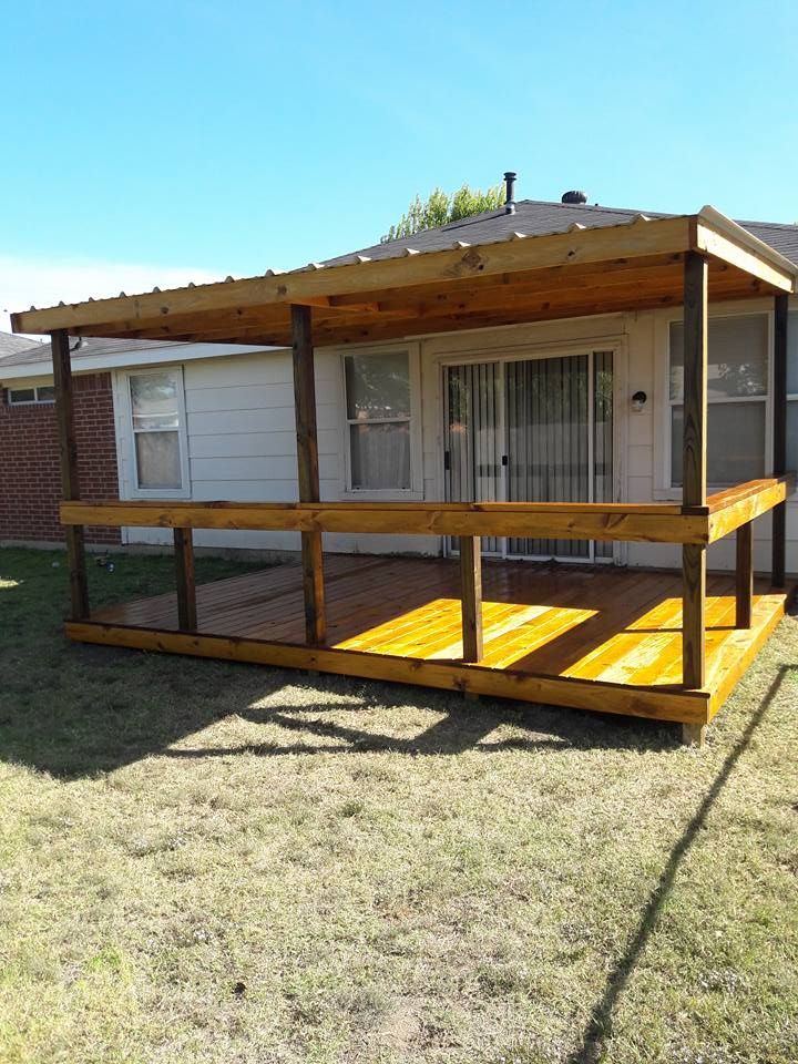 A small house with a wooden deck in front of it.