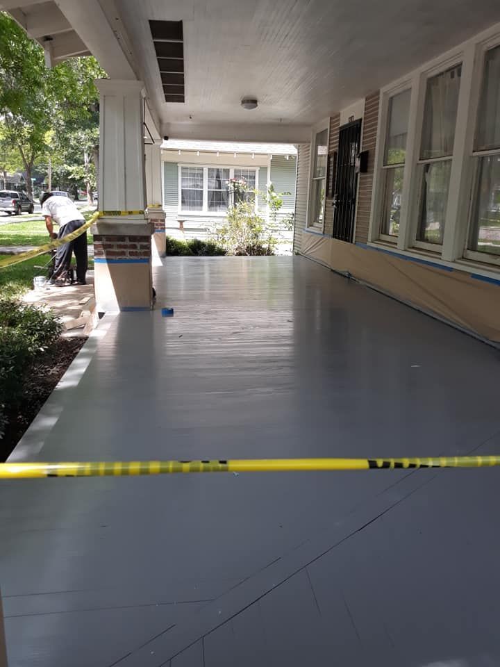 A porch of a house is being painted with a yellow tape.