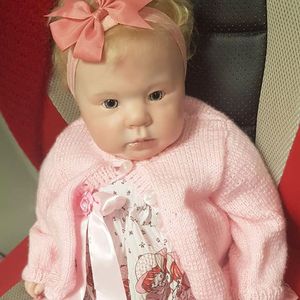 Reborn doll in pink cardigan