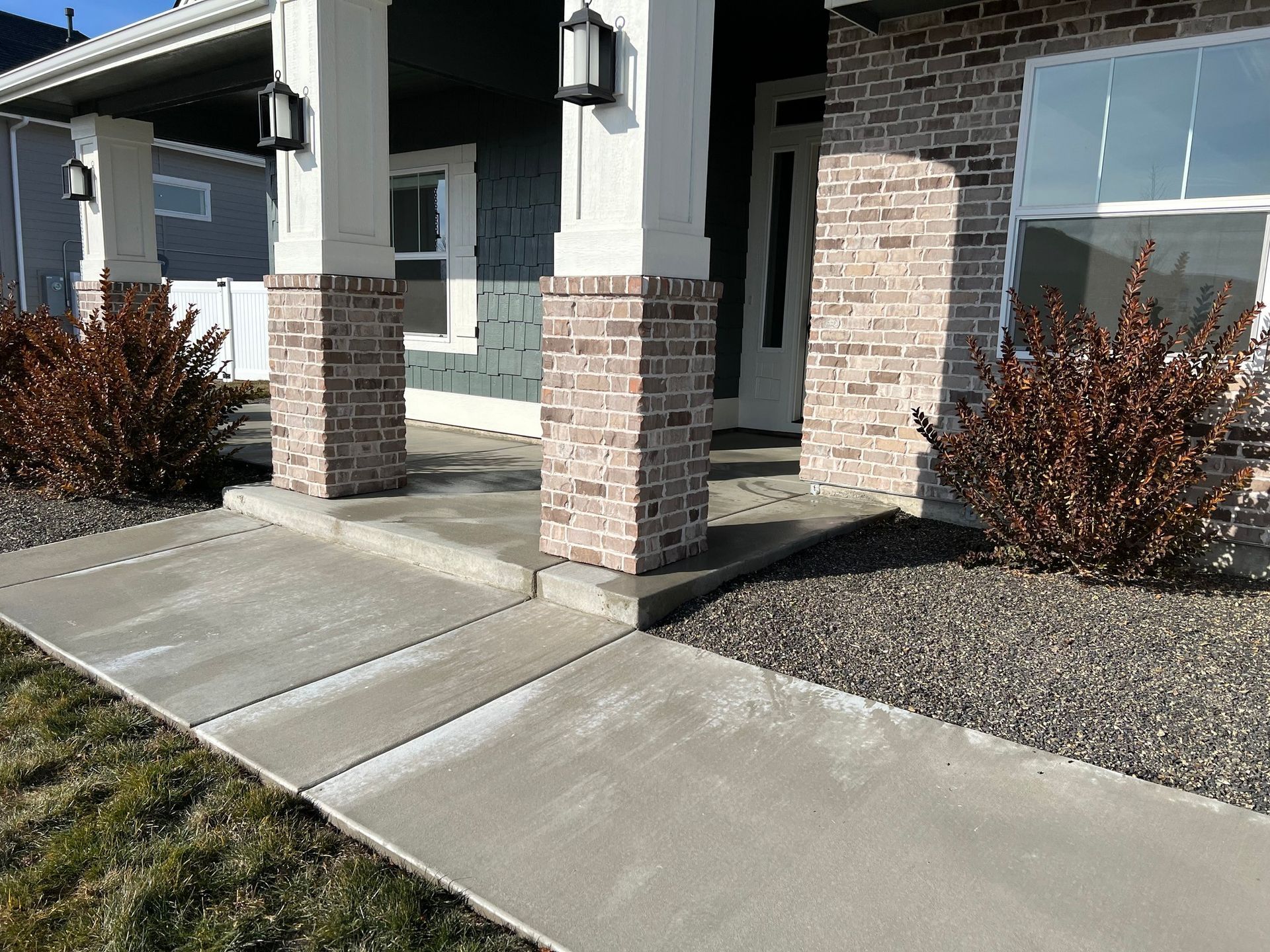 A brick house with a concrete walkway leading to it