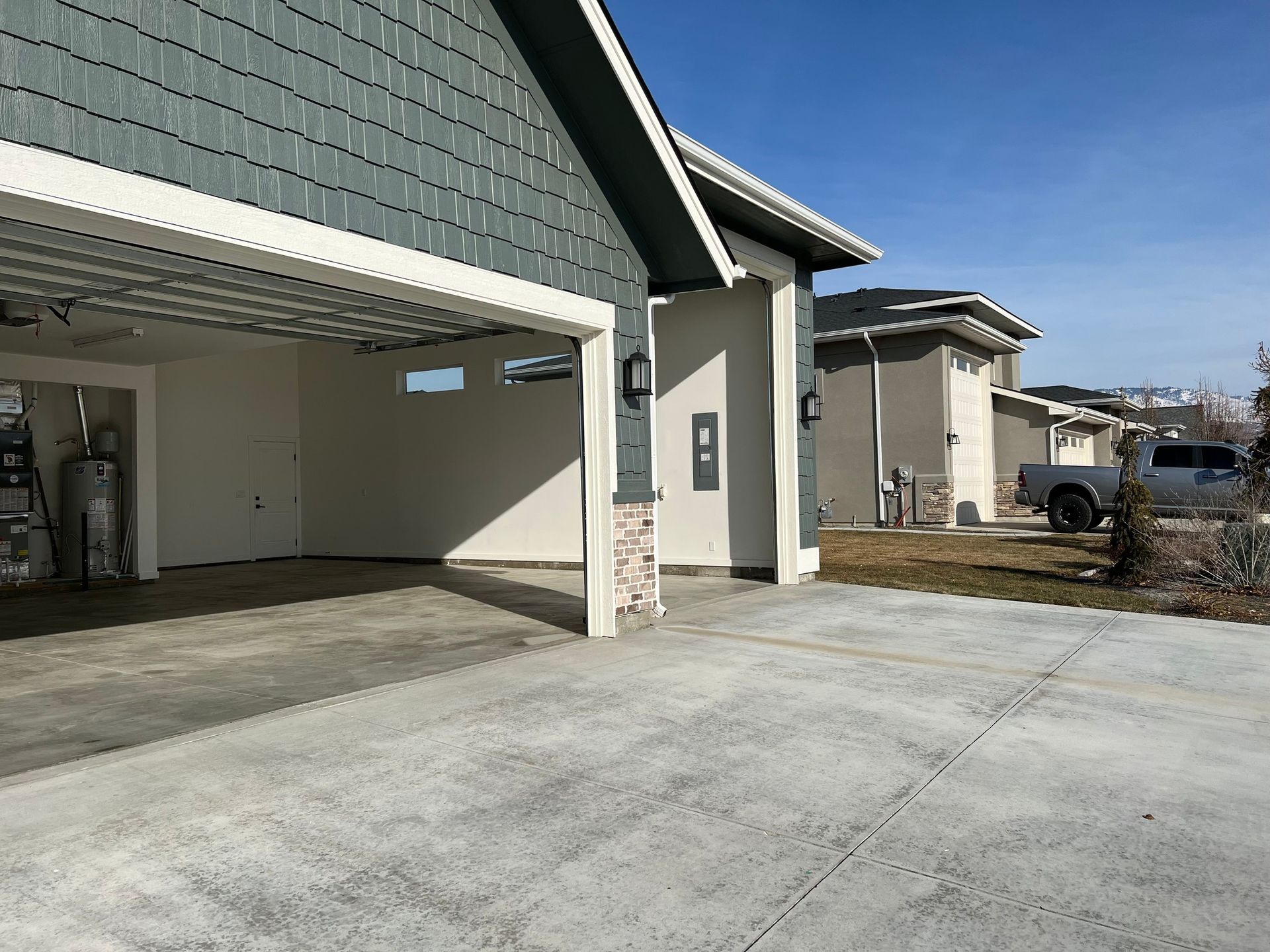 A garage with the door open and a truck parked in front of it.