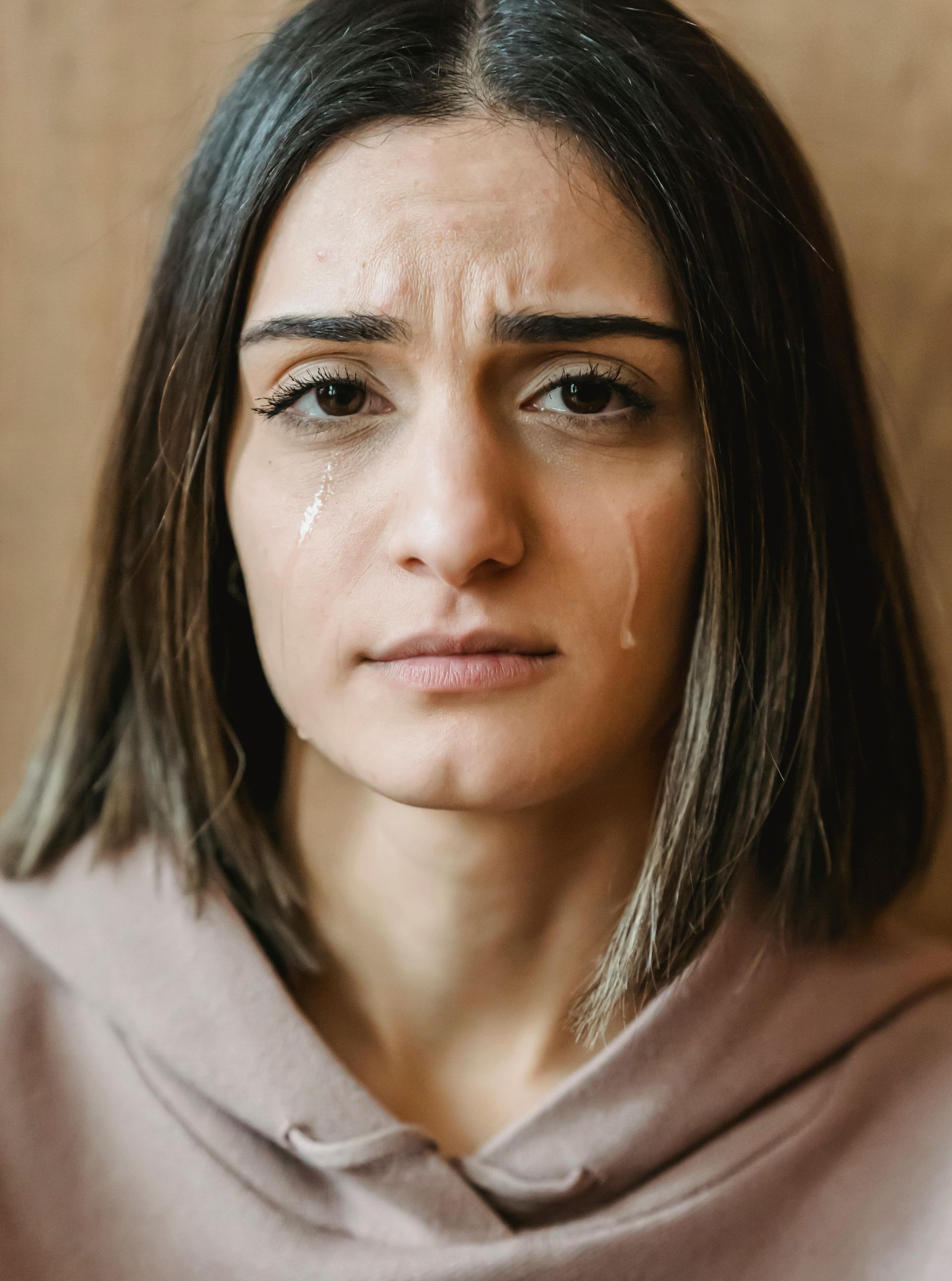A woman is crying with tears running down her face.