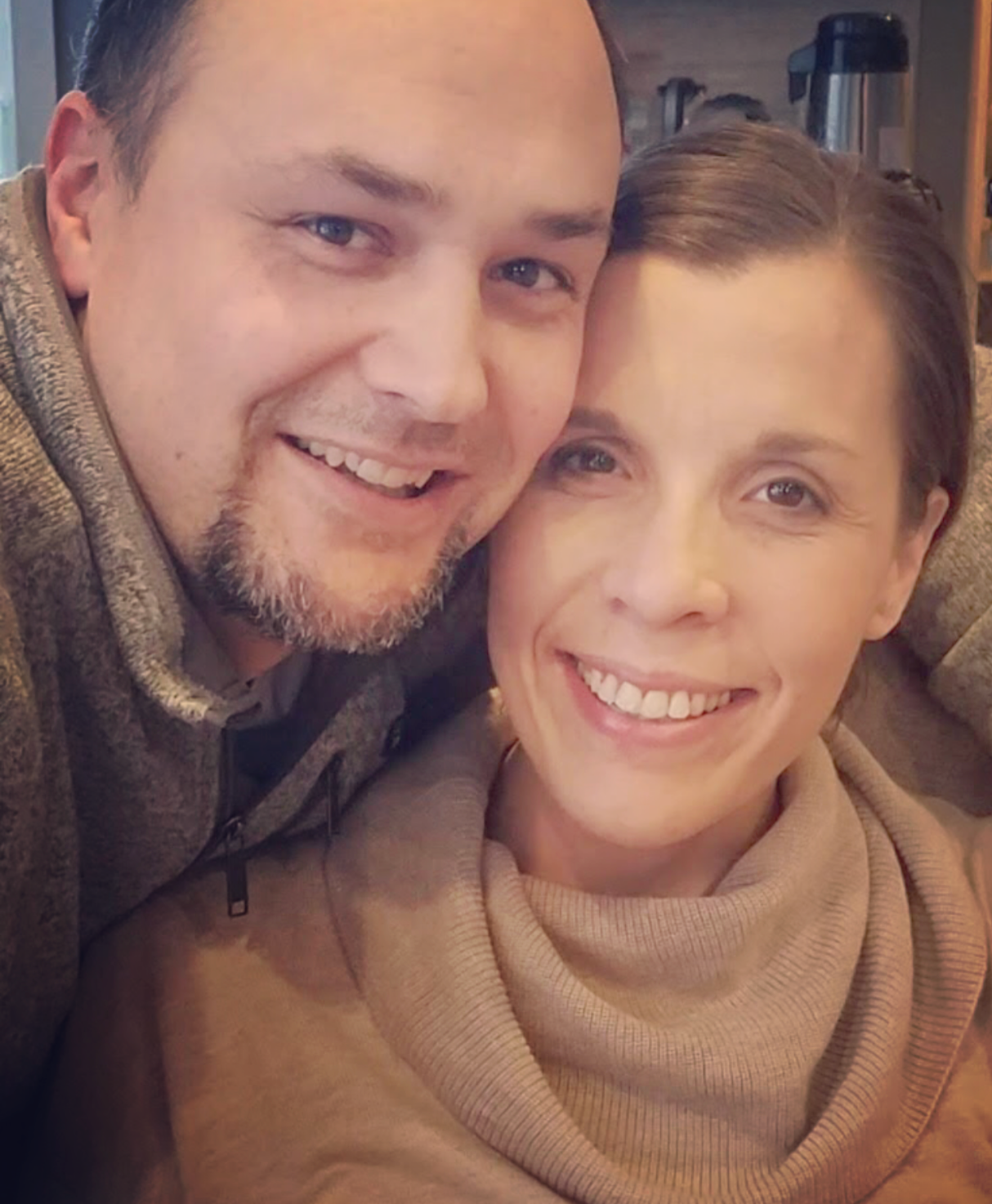 close up of amy and randy both smiling with happy eyes and faces amy wearing brown turtleneck