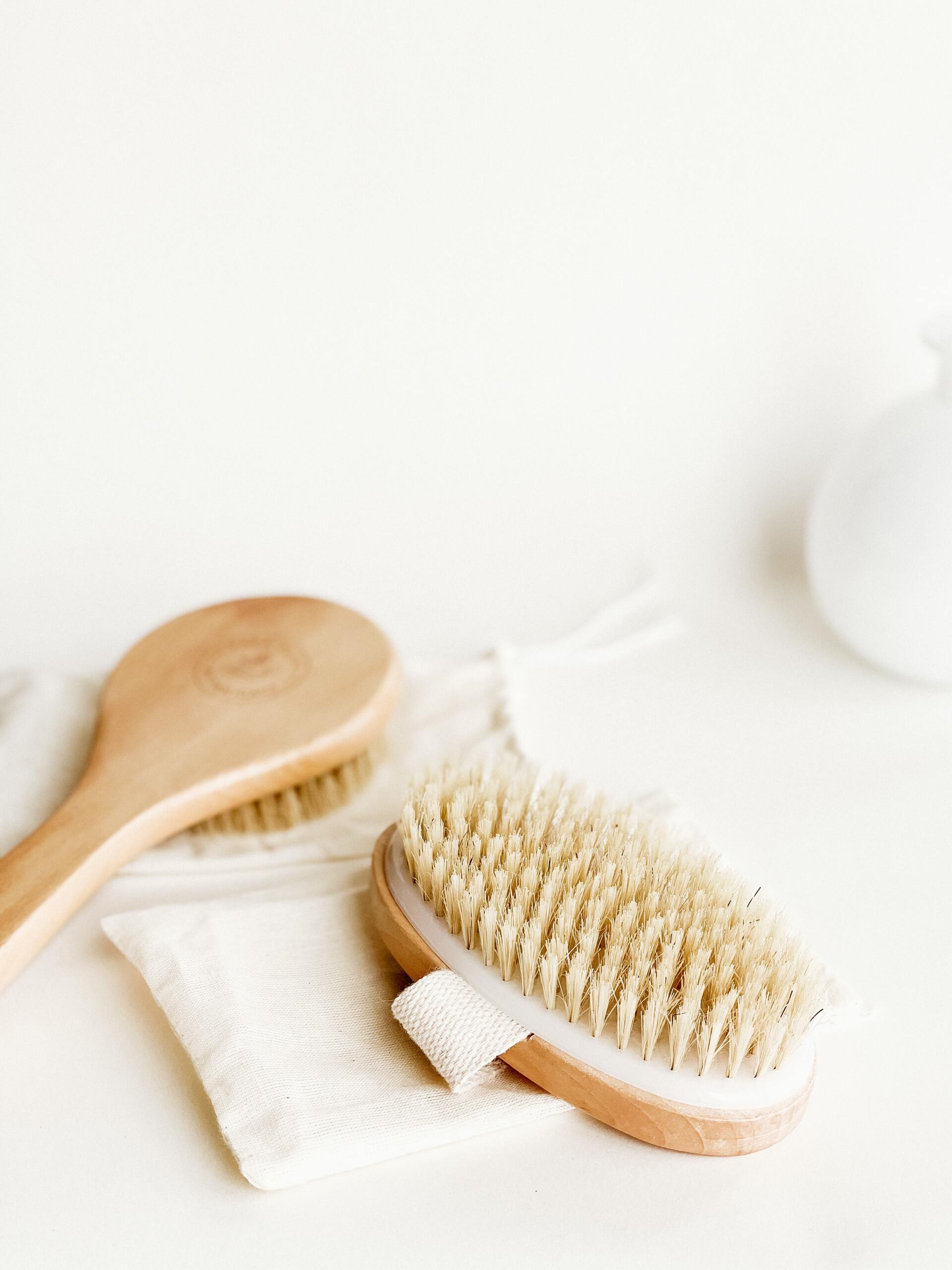 two different dry brushes on a white counter both resting on carrying bags. Crisp and clean bright photo on white countertop