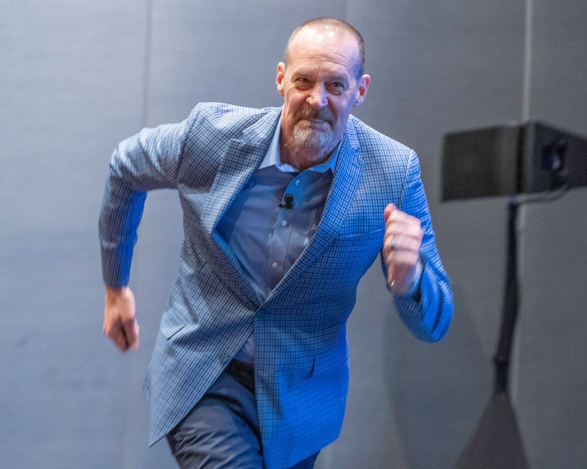 A man in a suit is running in a room.