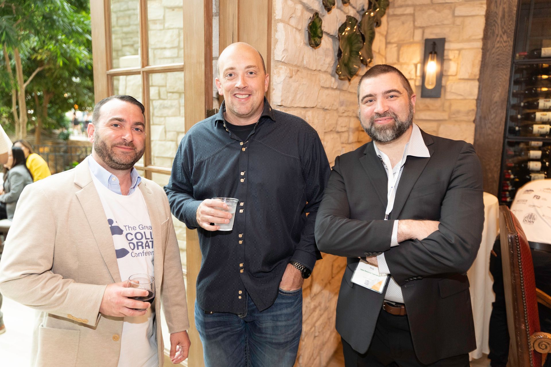 Three men are standing next to each other with their arms crossed.