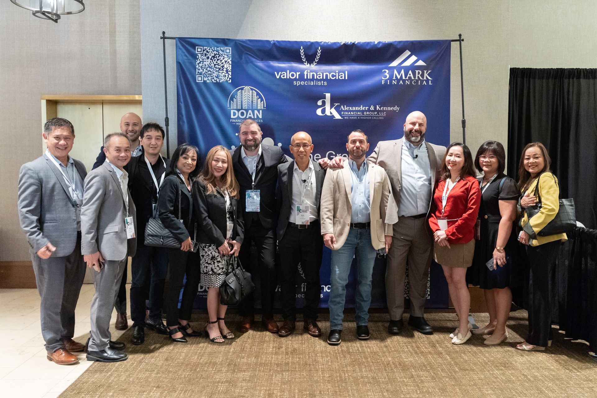 A group of people are posing for a picture in front of a blue backdrop.