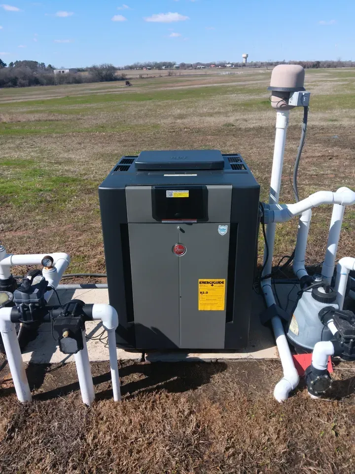 A pool heater is sitting in the middle of a field.