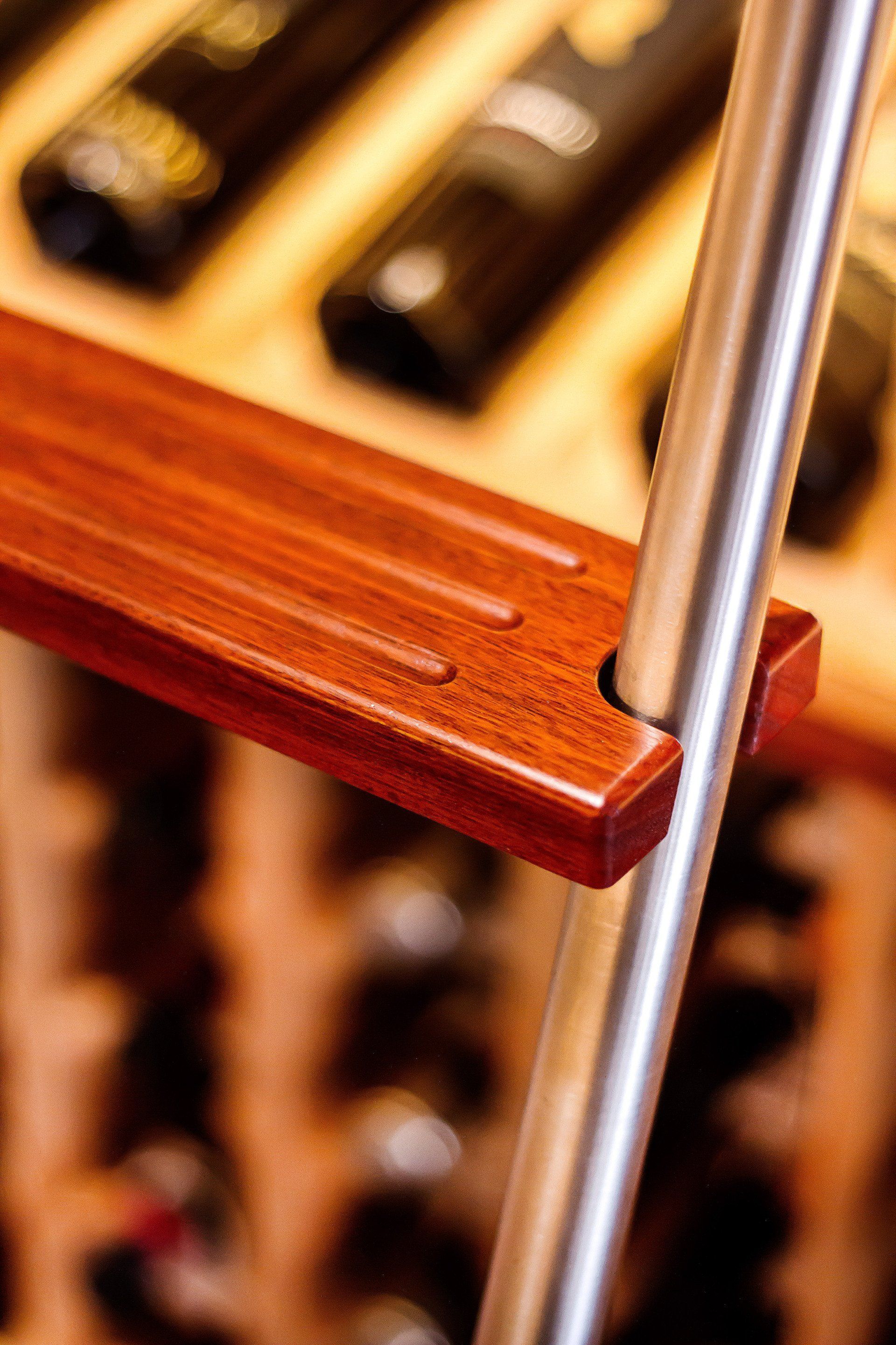 A Close up Of a Wooden Shelf with Bottles of Wine in The Background — Marlix Custom Timber Furniture Design and Joinery in Unanderra, NSW