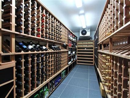 A Wine Cellar Filled with Lots of Wine Bottles on Wooden Shelves — Marlix Custom Timber Furniture Design and Joinery in Unanderra, NSW