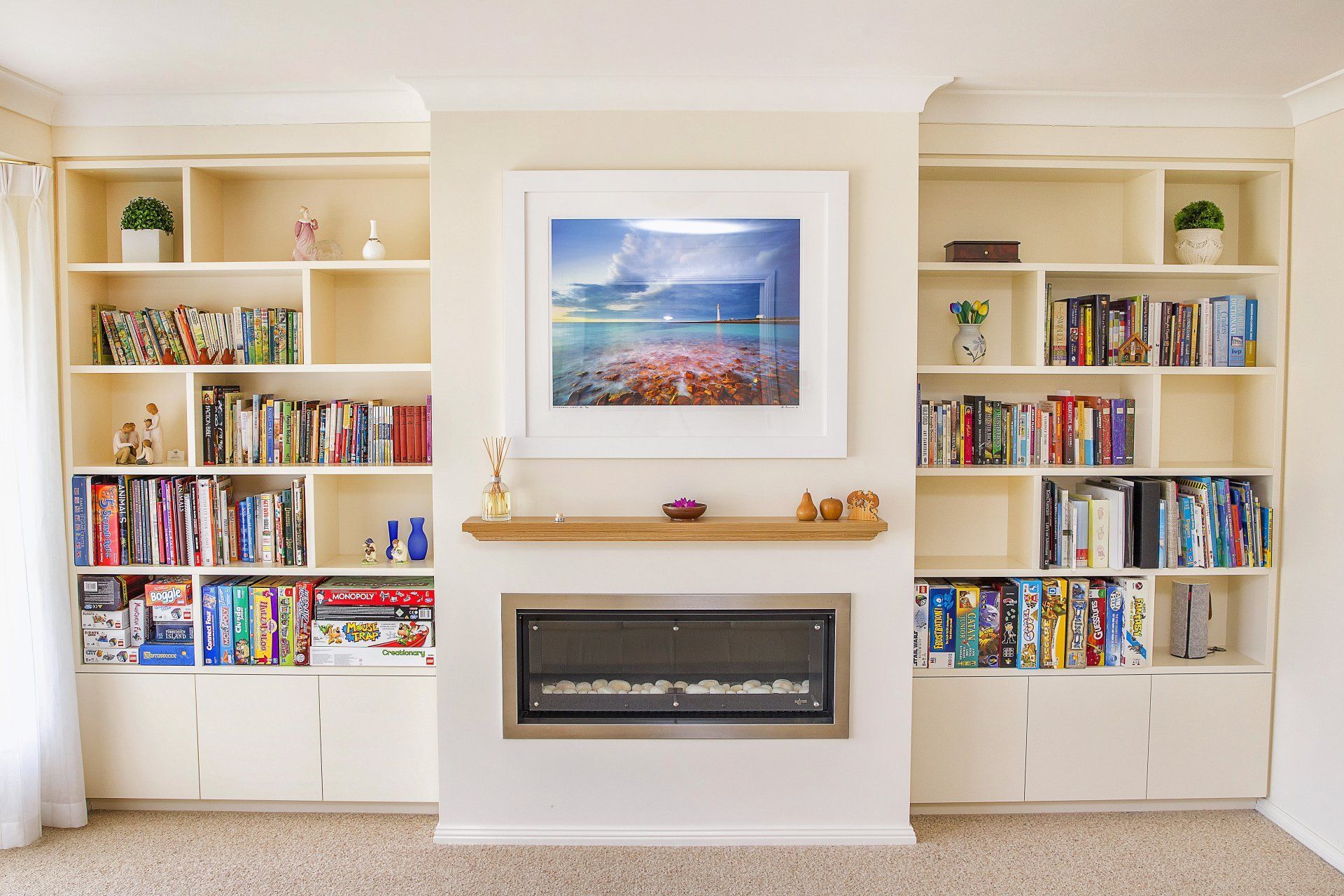 A Living Room with A Fireplace and Shelves Filled with Books — Marlix Custom Timber Furniture Design and Joinery in Unanderra, NSW