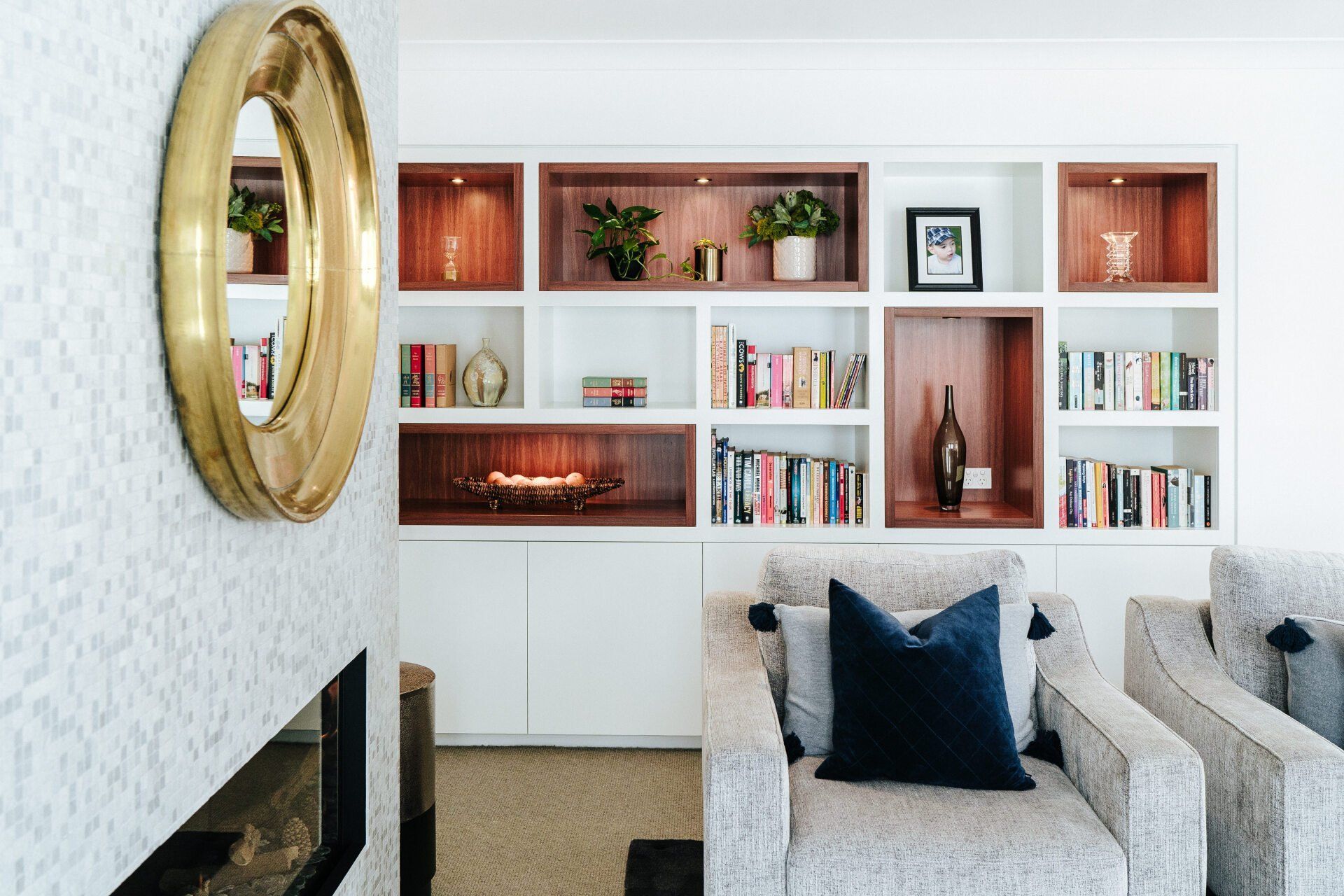 A Living Room with A Fireplace, Chairs, Shelves and A Mirror — Marlix Custom Timber Furniture Design and Joinery in Unanderra, NSW