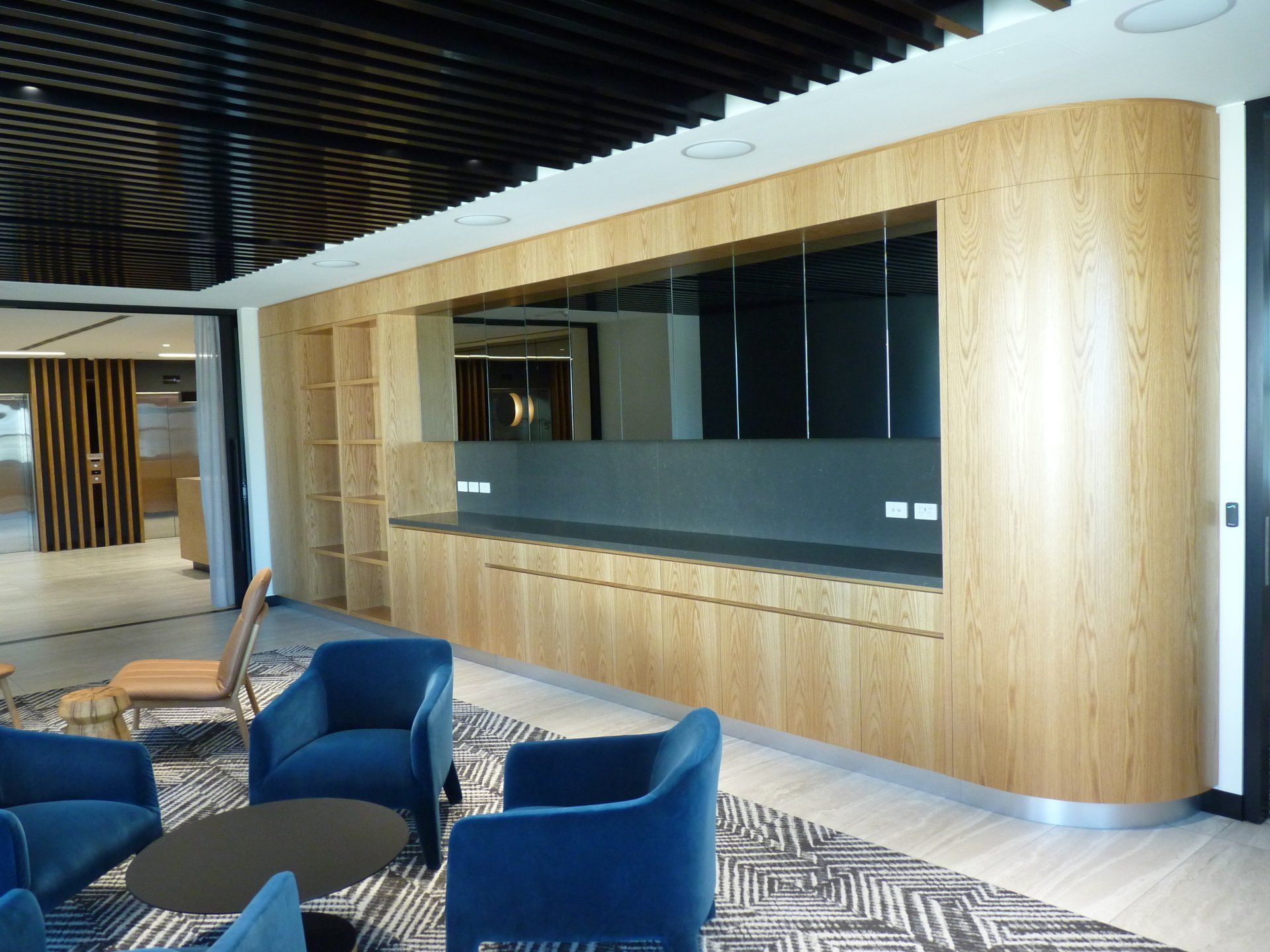 A Living Room with Blue Chairs, a Table, and A Wooden Wall — Marlix Custom Timber Furniture Design and Joinery in Unanderra, NSW