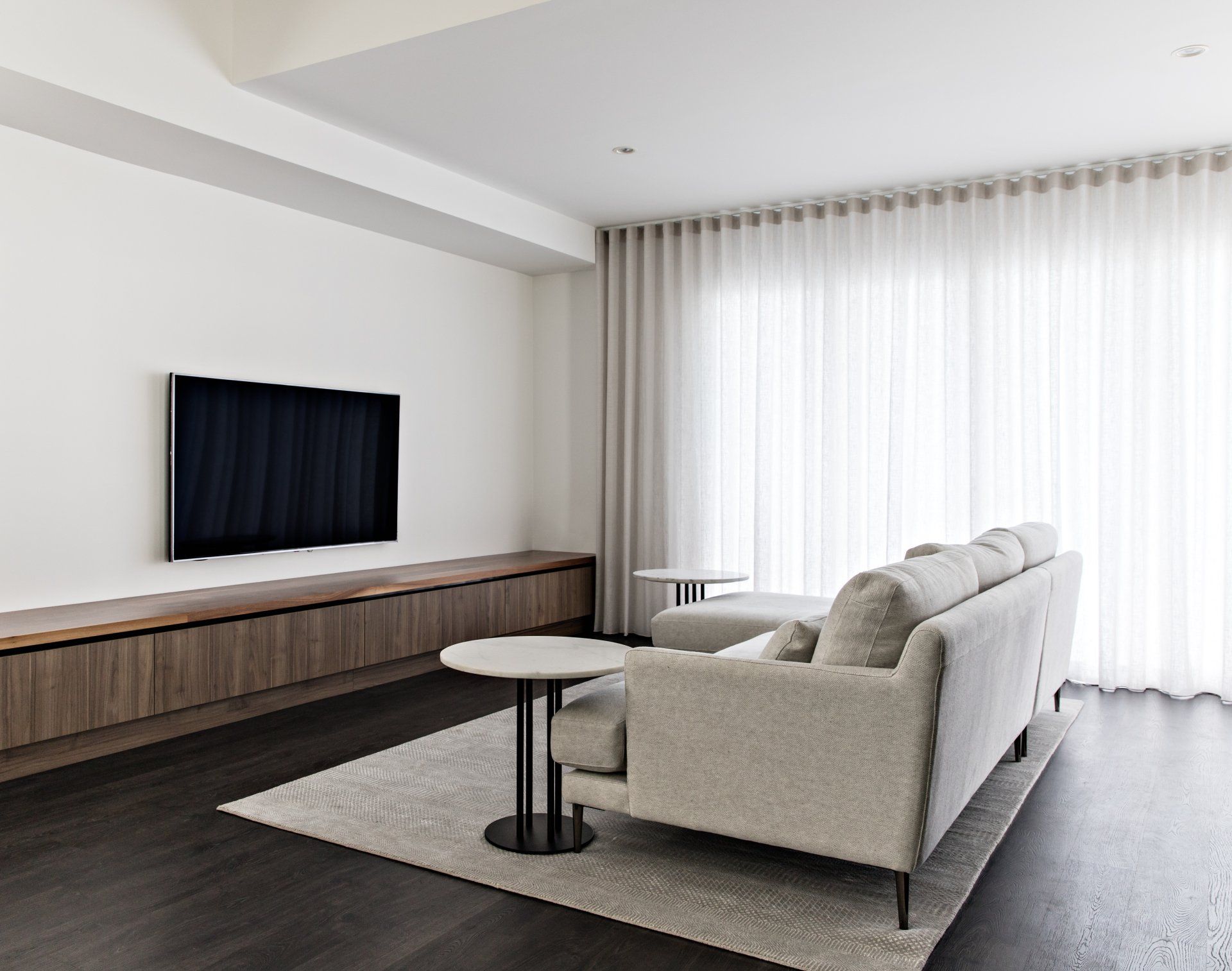 A Living Room with A Couch and A Flat Screen Tv on The Wall — Marlix Custom Timber Furniture Design and Joinery in Unanderra, NSW