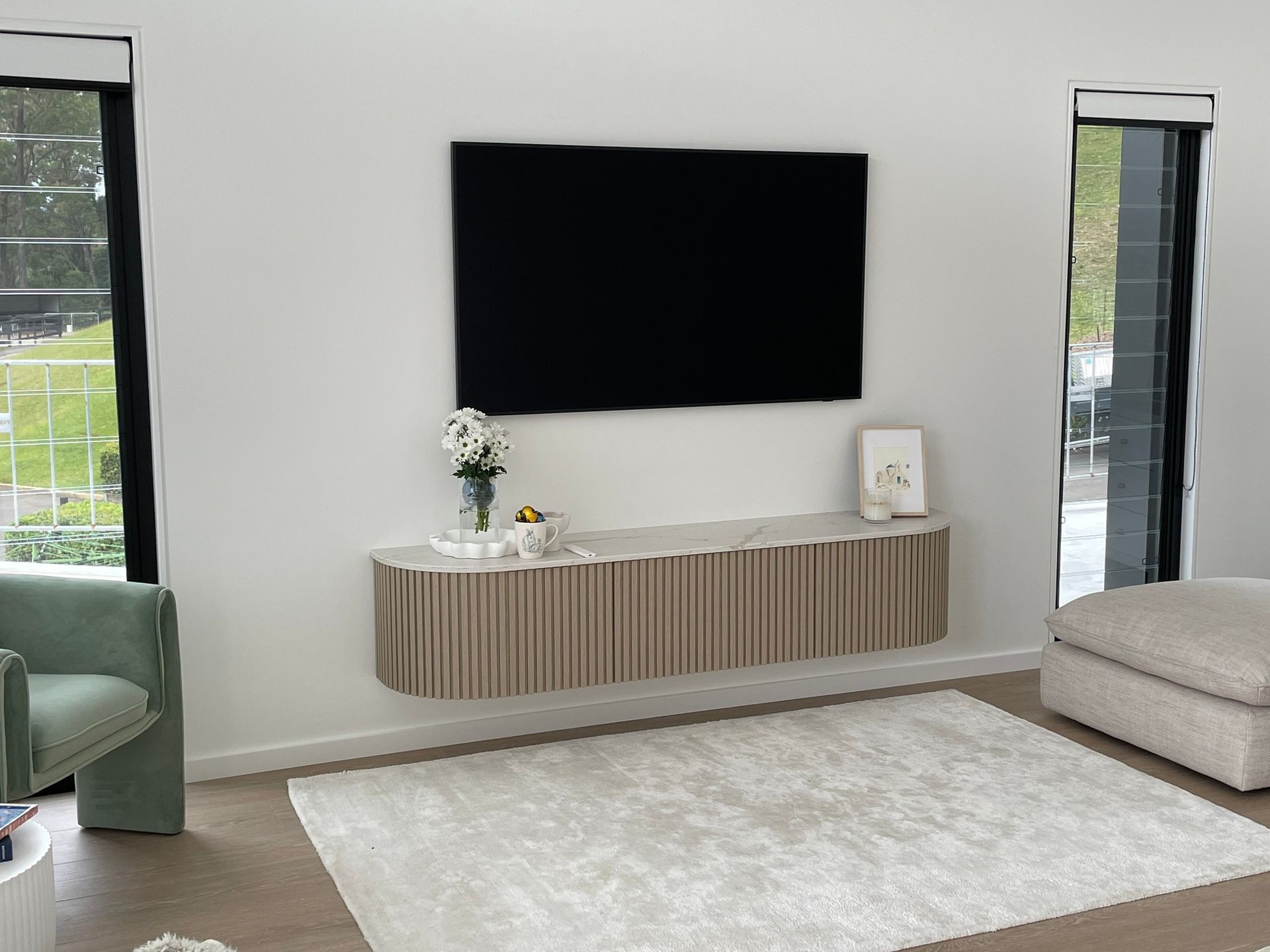 A Living Room with A Flat Screen Tv Mounted on The Wall — Marlix Custom Timber Furniture Design and Joinery in Unanderra, NSW